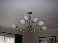 Gold coloured light fitting on white ceiling